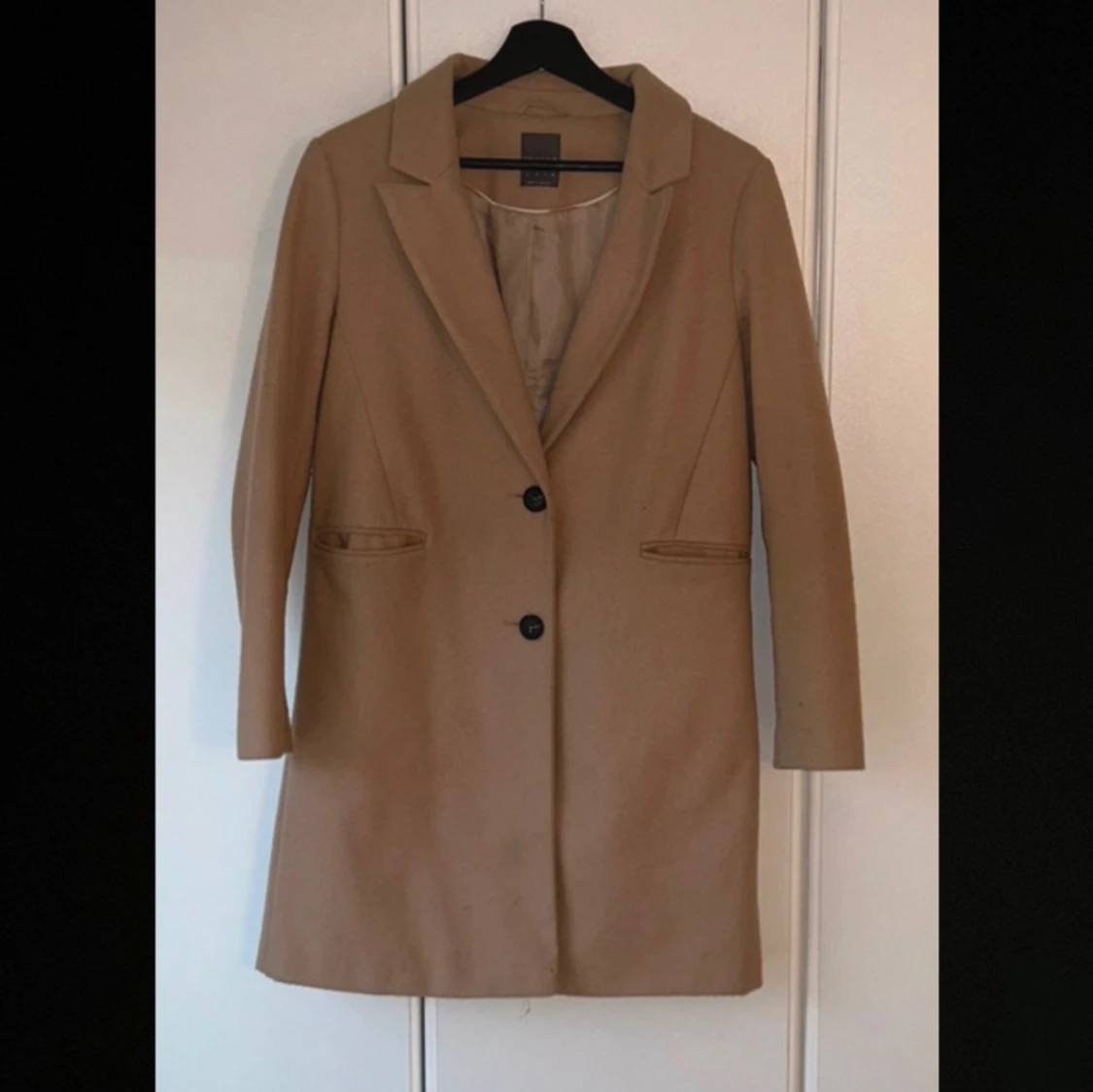 Beige kappa med knappar