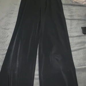 Svarta byxor från Bik Bok - Snygga svarta byxor från Bik Bok i storlek 34. De har en hög midja och en loose passform som ger en stilren look. Perfekta för både vardag och mer uppklädda tillfällen.