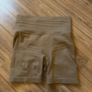 Bruna shorts med hög midja - Säljer ett par bruna shorts med hög midja och ribbad detalj i midjan. Perfekta för en bekväm och stilren look.