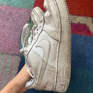 Vita Nike Air Force sneakers - Säljer ett par klassiska vita Nike Air Force sneakers. Skorna har en ikonisk design med snörning och en robust sula. Perfekta för en casual look.