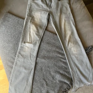 Grå jeansbyxor från D-XEL - Snygga grå jeansbyxor från D-XEL med klassisk femficksdesign och dragkedja. Byxorna har en rak passform och är perfekta för en avslappnad stil. De är tillverkade i ett slitstarkt material som ger en bekväm känsla hela dagen.