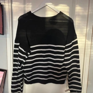 Svart och vit randig tröja - Säljer en stilren svart och vit randig tröja med långa ärmar. Perfekt för en avslappnad look. Tröjan har en klassisk design med horisontella ränder och en bekväm passform.