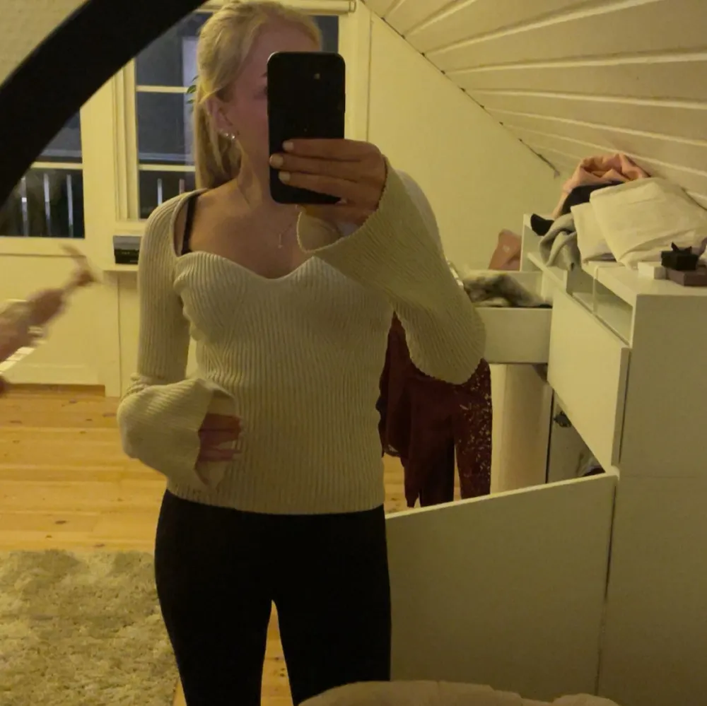 Säljer en stilren beige ribbad tröja med v-ringad design. Tröjan har långa ärmar och en figurnära passform och sitter väldigt fint. Skriv för fler bilder🌸Den är kremevit i färgen. Neuletakit & Villapaidat.