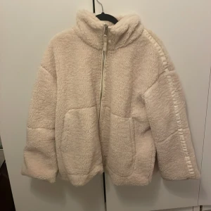 Beige teddyjacka med dragkedja - Mysig beige teddyjacka med dragkedja framtill. Aldrig andvänt därför att den är köpt i en för stor storlek💕  