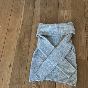 Grå stickad tröja från MNG - Säljer en mysig grå stickad tröja från MNG. Tröjan har en off Shoulder och långa ärmar, perfekt för kyliga dagar. Den ribbade strukturen ger en stilren look. Passar bra till både jeans och kjol. Hör av dig vid intresse!
