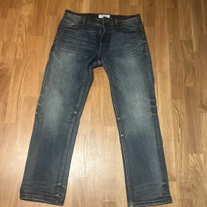 Blå jeans från Smog/Denim - Säljer ett par klassiska blå jeans från Smog/Denim. De har en straight passform och är tillverkade i slitstarkt denim. Perfekta för en avslappnad stil.