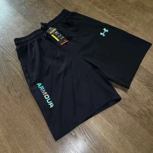 Svart kortärmad t-shirt från Under Armour - Snygg svart kortärmad t-shirt från Under Armour med färgglad logga på bröstet och text längs sidan. Perfekt för träning eller vardagsbruk.