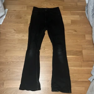 Svarta bootcut jeans från Pieces - Snygga svarta bootcut jeans från Pieces. De har en klassisk femficksdesign och knappgylf. De har även två små hål mellan benen.