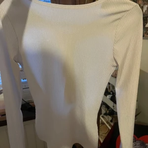 Vit ribbad topp med knyt - Säljer en stilren vit ribbad topp med långa ärmar och en snygg knytning i ryggen. Den är från Gina tricot i st S💗