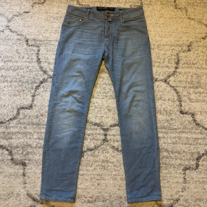 Ljusblåa Jacob cohen jeans - Säljer dessa trendiga och snygga ljusblåa Jacob cohen jeans. Jeansen är i storlek 31. Passar dig perfekt som är mellan 165-180cm. Modell 688. Skick 9,5/10, Inga defekter. Nypris runt 5500kr. Tveka ej på att skriva ifall du har frågor eller funderingar! 