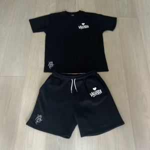 Valerra summer set - sommarset från Valerra, bestående av matchande T-shirt och shorts. Setet har en minimalistisk design med en broderad logga på bröstet och en större tryckt logga som ger en modern touch.  Materialet är av premiumkvalitet – huvudsakligen bomull – vilket gör det både bekvämt och perfekt för varma dagar. Det här setet är en del av en exklusiv drop och kommer med största sannolikhet inte att släppas igen i år.  Perfekt för dig som gillar stilrena, street-inspirerade plagg med hög kvalitet