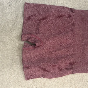 Vinröda seamless träningsshorts - Snygga vinröda seamless shorts med tight passform och ventilerande mesh-detaljer upptill och nedtill. Perfekta för gymmet eller löprundan, med stretchigt material som ger bra rörelsefrihet.