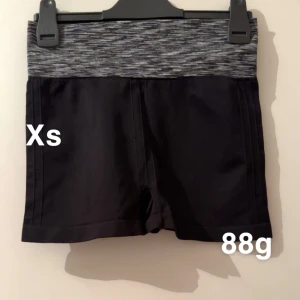 Svarta träningsshorts XS - Svarta träningsshorts med bred, mönstrad midja i grått och vitt. Shortsen har en tight passform och är perfekta för gymmet eller löpning. Snygg och sportig look med bekväm elastisk midja. 🌸Fint använt skick. Storlek xs