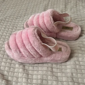 rosa tofflor - Supermjuka och fluffiga tofflor från UGG i ljusrosa färg. Perfekta för att chilla hemma eller ge din outfit en cozy vibe. Vet inte om de är äkta. Storlek 37.