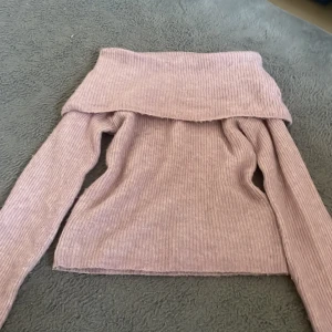 Ljuslila offshoulder tröja BikBok XS - Superfin ljuslila ribbad offshoulder-tröja från BikBok i mohairblandning. Tröjan har lång ärm och bred krage som vilar snyggt över axlarna. Perfekt för dig som gillar en mysig men ändå trendig look.