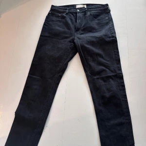 Jeanerica jeans - Svarta jeansbyxor från Jeanerica i klassisk rak modell. Byxorna har fem fickor, bälteshällor och en snygg läderpatch bak. Materialet är en mix av bomull, polyester och elastan för skön stretch och passform. Perfekta till sneakers eller boots.
