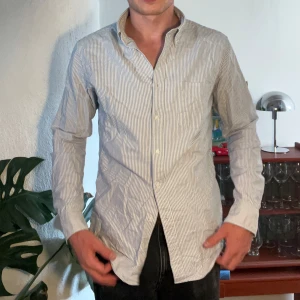 Arket randig skjorta - Randig blå-vit skjorta från arket, står ”slim fit” men köper inte det. Tänk mer ”regular fit”. Perfekt skjorta för alla lägen.