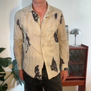 L’homme rouge skjorta - Otrolig skjorta från L’homme rouge! Beige/dusty vit med svart mönster. Härligt krage och grym passform. (P.s. har samma i svart till försäljning också). Samfraktar gärna med andra grejer!