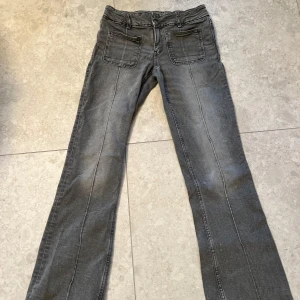 Gråa low waist jeans  - Snygga grå low waist jeans ifrån gina young med markerade sömmar längs framsidan. Jeansen har fyrkantiga fickor framtill och helt vanliga där bak. Säljer då dem är för korta! 