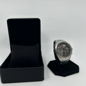 Champion herrklocka i silver med svart urtavla - Stilren herrklocka från champion med robust länkarmband i silverfärgat stål och svart urtavla med flera små ur. Klockan har tydliga index, datumvisning och kronograf-funktion. Perfekt accessoar för dig som gillar en klassisk och modern look.