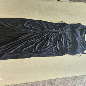 Svart långklänning från SHEIN MOD - Supersnygg svart långklänning från SHEIN MOD med smala axelband och draperad midja. Klänningen har figurnära passform och är tillverkad i mjuk viskosblandning med stretch. Perfekt för dig som vill ha en elegant och stilren look.