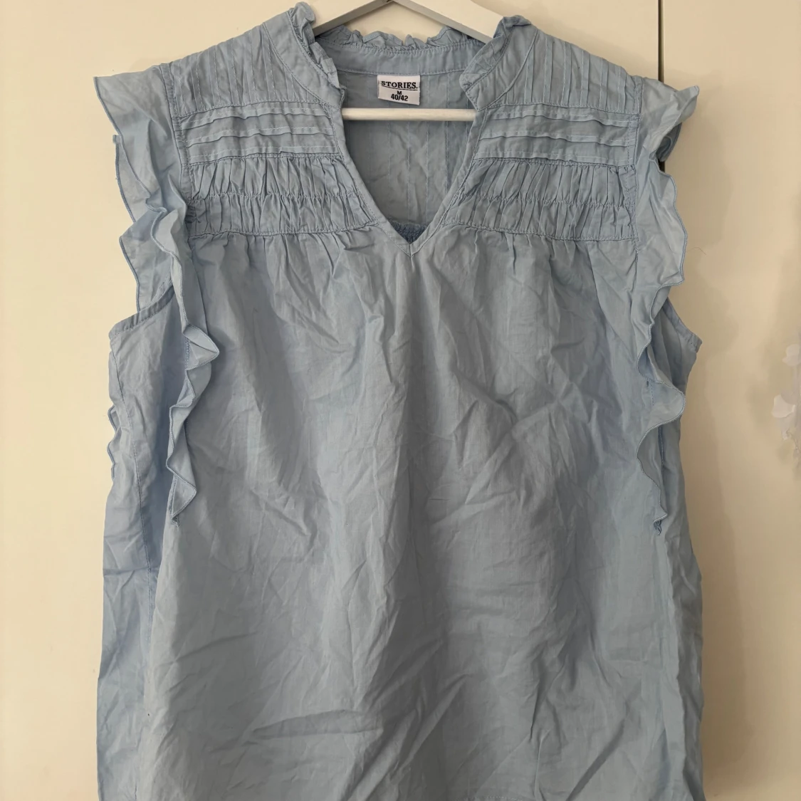 Ljusblå blus med volang