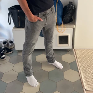 Grå slim jeans med slitning - Säljer ett par riktigt goa jeans med slitningar från jack and Jones, skriv om du har några funderingar eller frågor!!!