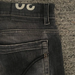 Svarta dondup jeans  - Goa dondup jeans i den klassiska modellen George, storlek 30 passform skinny fit. Jeansen har en go tvätt och en diskret sliten design. De är  i jätte fint skick, knappt använda. Skriv för frågor o funderingar. Möjlig defekt litet hål högra bakfickan, vilket är en del av slitningen. 