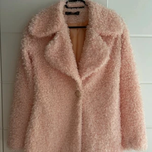 Ljusrosa teddyjacka med stor krage - Supermjuk och fluffig teddyjacka i ljusrosa med stor krage och en knapp framtill. 
