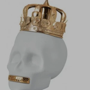 Parfymflaska i form av dödskalle - Unik parfymflaska formad som en vit dödskalle med en detaljerad guldfärgad krona på toppen. Flaskan har även en guldfärgad detalj vid munnen. Perfekt för dig som gillar edgy och cool design på din parfym.