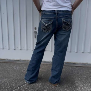 Midwaist baggy jeans - Baggy jeans med sömmar och strass på fickorna. Innerbenslängd: 79cm, midja: 46cm💙 personen på bilden ca 170cm