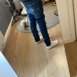 Mörkblå skinny jeans från Hollister - Säljer ett par mörkblå skinny jeans från Hollister med klassiska kontrastsömmar och snygga bakfickor med broderad detalj. Jeansen har låg midja och är tillverkade i stretchig bomullsdenim för en tight passform. Storlek w23 L29 men skulle säga att det fattar bättre som w26 L30.