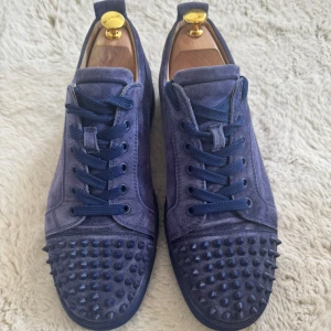Christian Louboutin skor - Säljer äkta Christian Louboutin low-top sneakers i exklusivt mörkblått mockaskinn med ton-i-ton nitar. Skorna är sparsamt använda och i mycket bra skick. Storlek EU 43, normal i storleken. Nypris cirka 8 000–9 000 kr. Perfekt för dig som vill ha exklusiva och unika sneakers. ✅ Skick: Mycket bra ✅ Färg: Mörkblå (navy) ✅ Storlek: EU 43 ✅ Nypris: 8 000–10 000 kr ✅ Äkta / Originala  📦 Snabb och säker frakt 💬 Hör gärna av dig vid frågor eller bud!
