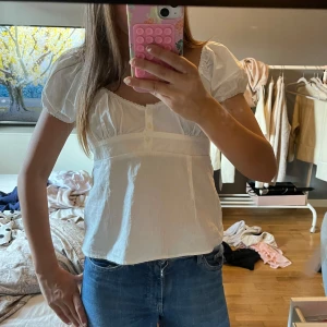 Vit blus från Brandy Melville - Supersöt vit blus från Brandy Melville med puffärmar, v-ringning och små knappar framtill. Så snygg aldrig använt den!! Köpt i barcelona🥰 storlek S men passar xs också!