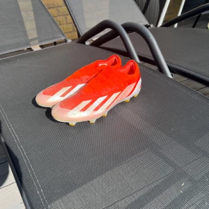 Röda adidas fotbollsskor med vita detaljer - Snygga Adidas Crazyfast elit skor. Är typ nya har använt dem få gånger.