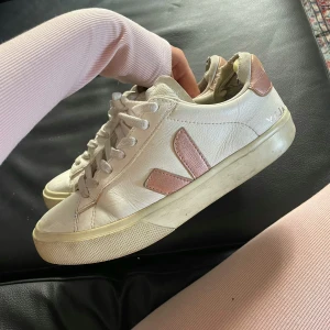 Veja skor - rosa - Snygga vita sneakers från Veja med ljusrosa detaljer och klassisk snörning. Dejekter: Sulan är extremt sliten på båda skorna.