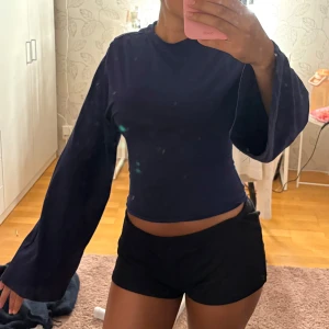 Mörkblå tröja från Nelly - Mörkblå tröja från Nelly med figur sydd midja och lösa armar. Storlek XS. Den är väldigt stretchig och skön. Säljer då jag ångrar mitt köp då den inte passar mig så bra. Köpt för 300kr och aldrig använd! 
