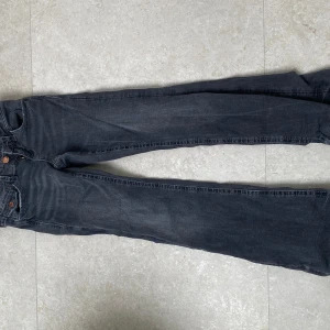 Grå jeans med paljettrosetter Gina Tricot - Mörkgrå jeans från Gina Tricot i storlek 152. Snygga raka ben och coola bakfickor med broderade rosetter och paljettdetaljer. Klassisk femficksmodell med knapp och dragkedja. Perfekta för dig som gillar lite extra detaljer på dina jeans.