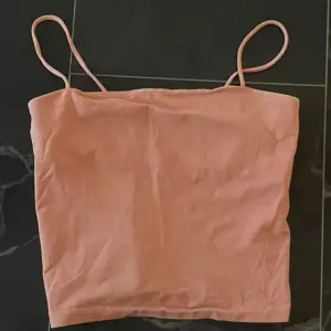 Kort rosa linne med smala axelband. I storlek S men passar XS också!