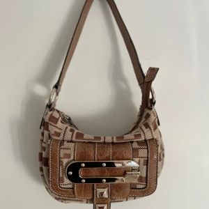Vintage Guess väska  - Äkta vintage Guess väska, köpt på vestiare Collective , väskan är i bra skick, det finns inga tecken på användning, väskan har inte heller någon ”gammal” lukt💕