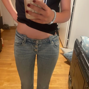 Super Lågmidjade ljusblå bootcut jeans - Säljer ett par lågmidjade ljusblå jeans med bootcut passform. Dom är jätte lågmidjade och inte nersydda. Jag har använt dom en gång så dom är praktiskt taget helt nya❤️pris kan diskuteras