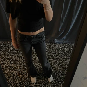 Svarta Gina tricot  Bootcut jeans  - Säljer ett par svarta jeans med bootcut-modell och låg midja med fickor bak. Från Gina tricot, stl 164. Är 163 cm och passar bra. Nytt pris 359kr