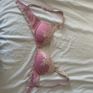 Rosa spets-bh från Intimissimi - Supersöt rosa bh från Intimissimi med ljusbeige spetsdetaljer och blommönster. Bh:n har vadderade kupor och justerbara axelband. Perfekt för dig som gillar romantiska och feminina underkläder.