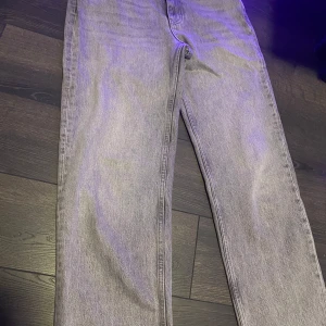Två par raka jeans i grått och ljusblått - Säljer två par raka jeans, ett par i grå tvätt  och ett par i ljusblå tvätt från ginatricot. Båda har klassisk femficksdesign, raka ben och hög midja. De ljusblå har slitna detaljer och rå kant nertill för en trendig look. Passar perfekt. 120 styck eller 200 för båda