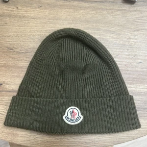 Moncler mössa  - Snygg olivgrön ribbstickad mössa från Moncler! Kvitto finns från NK Göteborg 