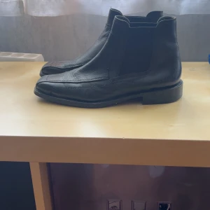 Svarta chelsea boots i skinn - Snygga svarta chelsea boots med spetsig tå och låg klack. Passar mig som har storlek 43. Fint skick utan defekter!