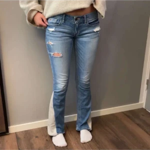 Ljusblå bootcut jeans med slitningar - Säljer ett par skit snygga lågmidjade bootcut jeans från hollister. Storlek W26, L29 men passar mig som är 166 och har 37 i midja🩷