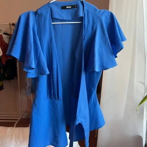 Blå blus - Super fin blus med band att knyta runt midjan som ger en super fin figur.