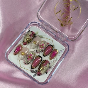 TropicDoll (S);Medium Almond - Snygga gelé press-on naglar i en medium mandelform med mix av rosa, svart, guld och nude. Designen har detaljer som blommor, stjärnor, prickar och 3D-rosetter. Perfekt för dig som vill ha unika och kreativa naglar utan att gå till salong. I storlek S: 15 mm, 11,5 mm, 12 mm, 11 mm, 9 mm 
