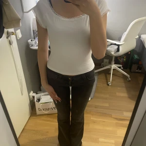 Vit topp med spetsdetaljer - Säljer en söt vit topp från shein med korta ärmar och fina spetsdetaljer längs halsringningen och ärmsluten. Modellen är figurnära och har en klassisk, enkel design som passar perfekt till jeans eller kjol. Superenkel att styla för en fräsch look!